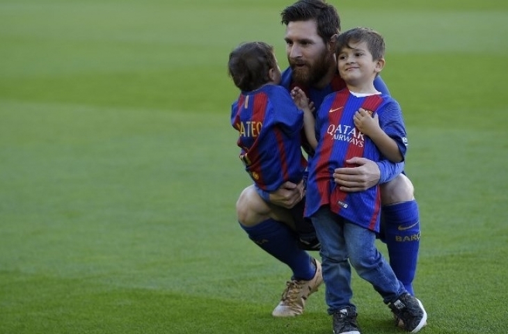 Bintang Barcelona Lionel Messi bersama dengan kedua anaknya Mateo (kiri) dan Thiago (kanan) di Camp Nou. LLUIS GENE / AFP