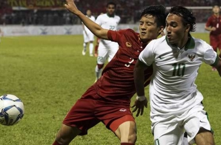 Pemain Timnas Indonesia U-22 Ezra Walian (kanan) berebut bola dengan pemain Timnas Vietnam U-22 Hoang Van Khanh dalam babak penyisihan grup B SEA Games XXIX [Antara]