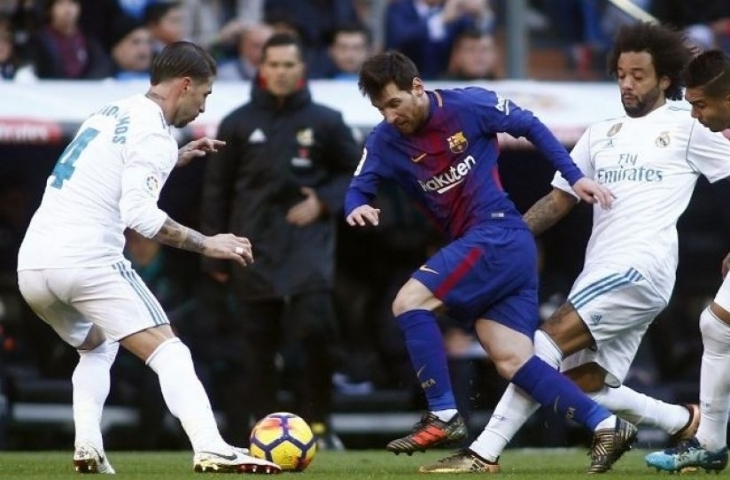 Pemain Barcelona Lionel Messi (tengah) melewati tiga pemain Real Madrid [AFP]