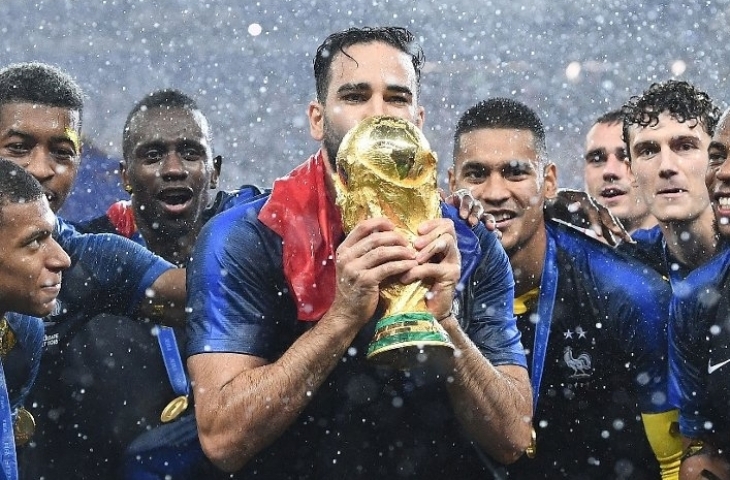 Adil Rami mencium trofi Piala Dunia 2018