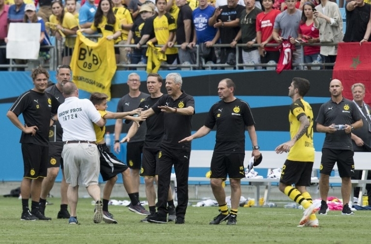 Christian Pulisic menyuruh petugas keamanan melepas seorang anak (22/7). [Jim Watson/AFP]