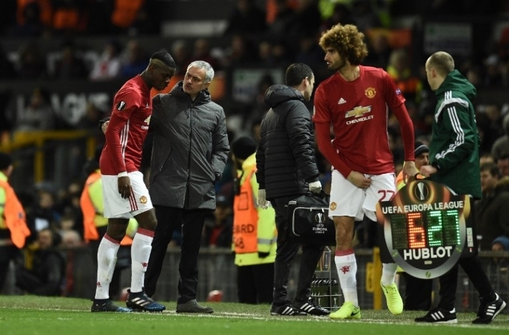 Jose Mourinho berbicara dengan Paul Pogba ketika menariknya keluar lapangan (Oli Scarff/AFP)