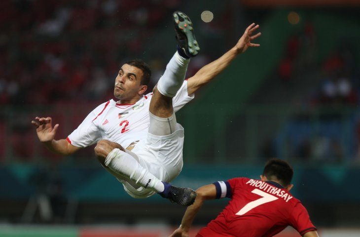 Pemain timnas Palestina Amed Qatmish (kiri) saat menghalau serangan pemain Laos Phouttthasa Khochalern pada pertandingan Grup A Asian Games 2018 di Stadion Patriot, Bekasi Minggu (12/8). (ANTARA/INASGOC/Charlie)