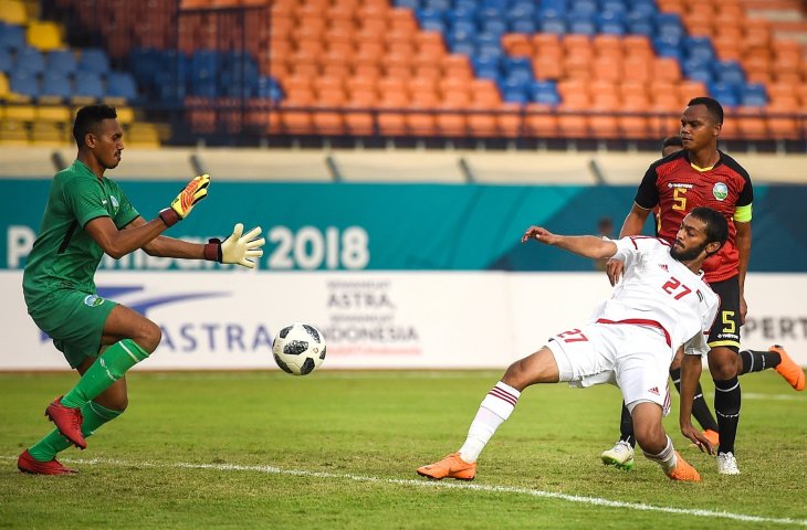 Gelandang Uni Emirat Arab (UEA) Zayed Alameri (kanan) menendang bola ke gawang kiper Timor Leste Aderito Raul Fernandes (kiri) saat menjalani babak penyisihan cabang olahraga sepak bola Asian Games group C antara Timor Leste melawan Uni Emirat Arab di Stadion Jalak Harupat, Kabupaten Bandung, Jawa Barat, Kamis (16/8). (ANTARA/INASGOC/Raisan Al Farisi)