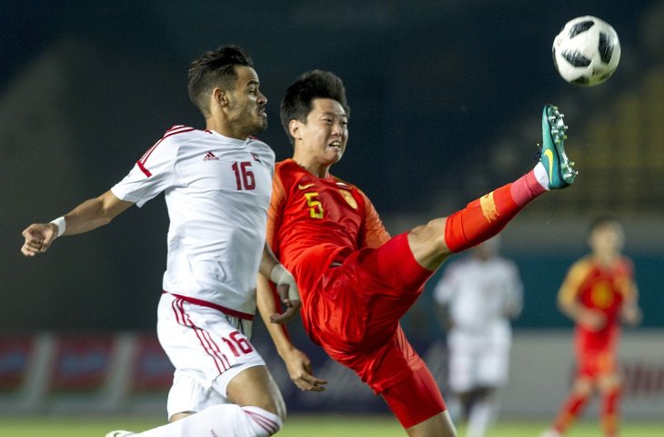 Pemain timnas Cina Gao Zhunyi (kanan) berebut bola dengan pesebak bola Uni Emirat Arab Alyahyaee Ali pada pertandingan babak penyisihan sepakbola Grup C Asian Games 2018 di Stadion Si Jalak Harupat, Soreang, Kabupaten Bandung, Jawa Barat, Minggu (19/8). (ANTARA FOTO/INASGOC/Novrian Arbi)