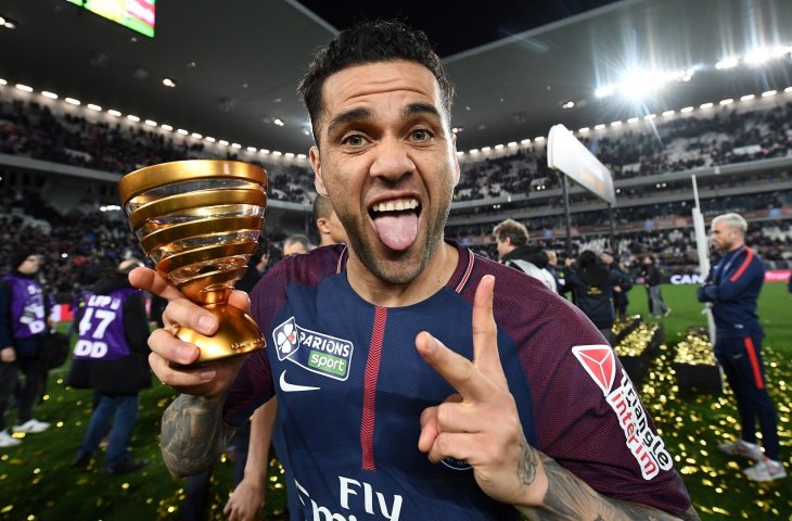 Pemain Paris Saint Germain Daniel Alves memegang trofi Piala Liga Prancis setelah mengalahkan Monaco di The Matmut Atlantique Stadium in Bordeaux,Prancis (31/3/2018) (AFP)