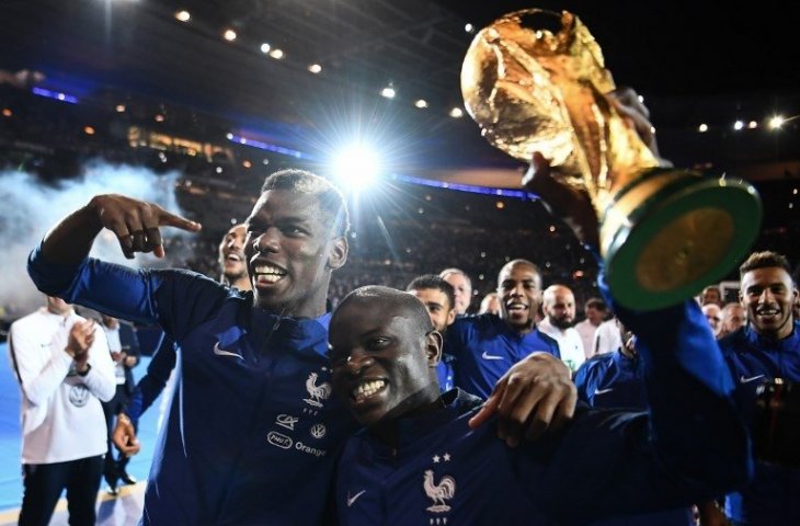 Paul Pogba (kiri) dan N'Golo Kante (kanan) saat merayakan keberhasilan mereka menjuarai Piala Dunia 2018 di depan para pendukungnya di ajang UEFA Nations League (Franck Fife/AFP)