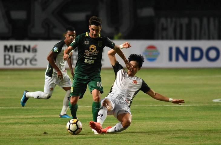 Pemain Persebaya Surabaya Robertino Pugliara (kedua kanan) berebut bola dengan pesepak bola PS Tira Jeon Wooyoung (kanan) dalam lanjutan Liga 1 Indonesia 2018 di Gelora Bung Tomo (GBT) Surabaya, Jawa Timur, Selasa (11/9). (ANTARA FOTO/M Risyal Hidayat)