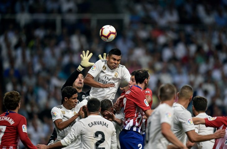 Pemain Real Madrid, Casemiro (tengah) saat duel udara di pertandingan antara Real Madrid vs Atletico Madrid di Stadion Santiago Bernabeu (AFP)