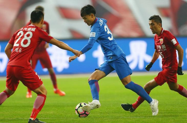 Pemain Shanghai Shenhua, Liu Ruofan (biru) berusaha melewati pemain Shanghai SIPG, He Guan (AFP)