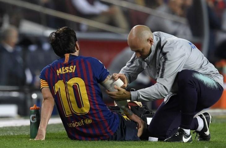 Lionel Messi saat menerima perawatan medis saat terkena cedera melawan Sevilla (Lluis Gene/AFP)