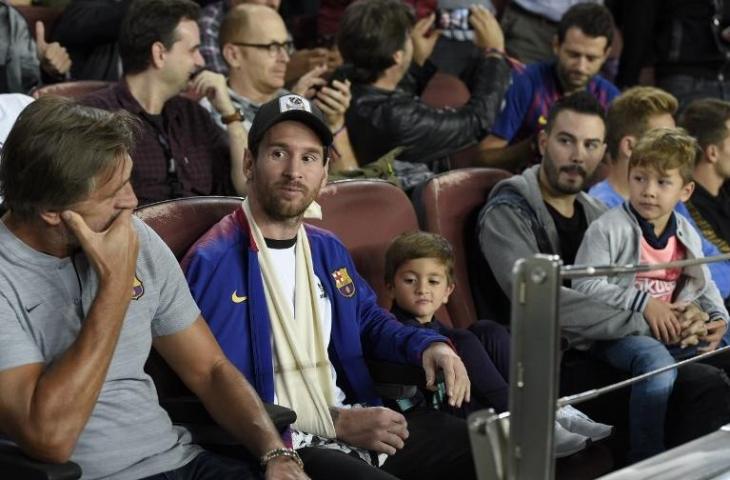 Lionel Messi dan Thiago menyaksikan laga Barcelona vs Inter Milan. (Lluis Gene/AFP).