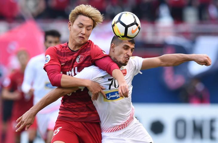 Pemain Kashima Antlers, Jung Seunghyun (kiri) dan Pemain Persepolis, Ali Alipour (kanan) memperebutkan bola di final Liga Champions Asia 2018 (AFP)