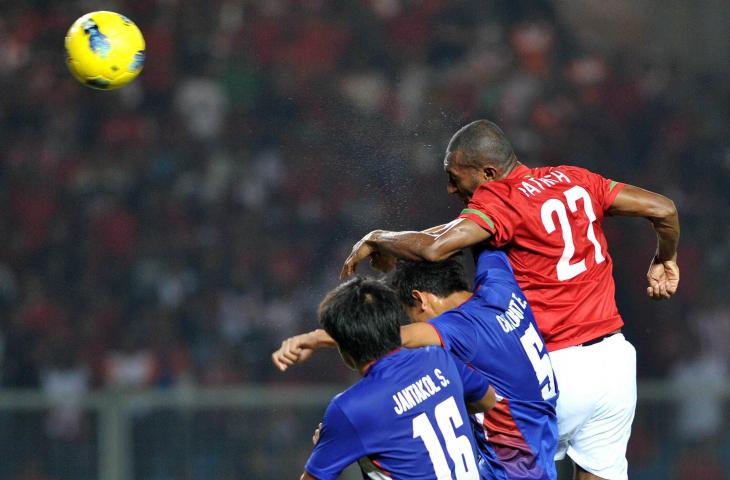 Pemain Timnas Indonesia, Patrich Wanggai melakukan duel udara dengan pemain Thailand Sutjarit Jantakol dan Ekkasit Chaobut pada saat SEA Games 2011 di Jakarta (13/11/2011). (AFP PHOTO / ADEK BERRY)