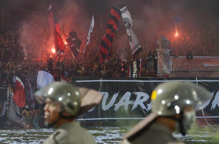 Suporter Bali United menyalakan flare ketika berlangsungnya pertandingan Sepak Bola Liga 1 antara Bali United melawan Persija Jakarta di Stadion I Wayan Dipta, Gianyar, Bali, Minggu (02/12/2018). Persija Jakarta menang atas Bali United dengan skor 2-1 setelah beberapa kali pertandingan sempat dihentikan karena ulah penonton. (ANTARA FOTO/Nyoman Budhiana)