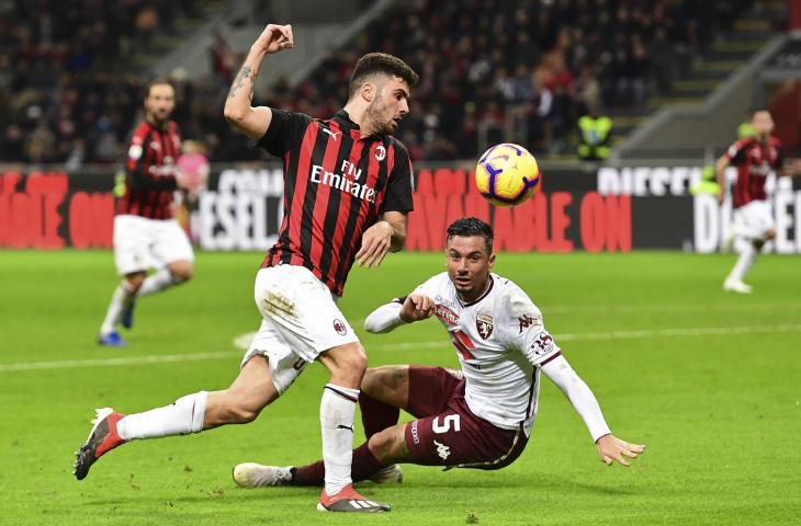 Pemain AC Milan, Patrick Cutrone melewati pemain Torino Armando Izzo saat pertandingan Serie A pekan ke-15 di Stadion San Siro (9/12/2018)