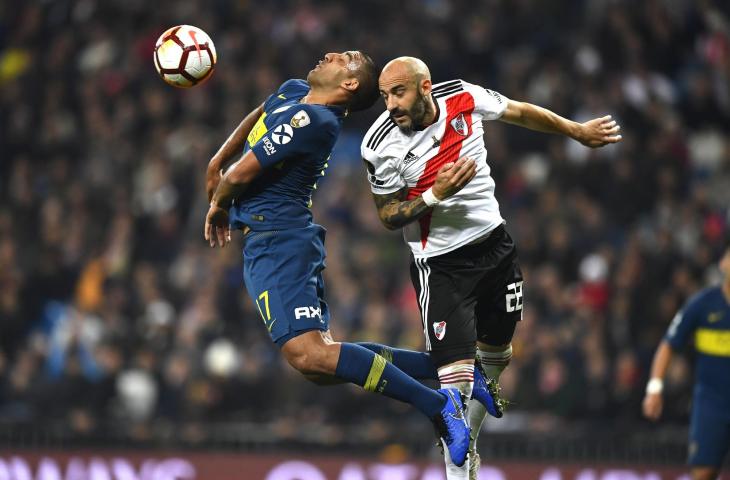 Pemain Boca Juniors, Ramon Abila duel udara dengan pemain River Plate, Javier Pinolasaat saat partai final leg kedua Copa Libertadores di Santiago Bernabeu, Madrid, (9/12/2018)