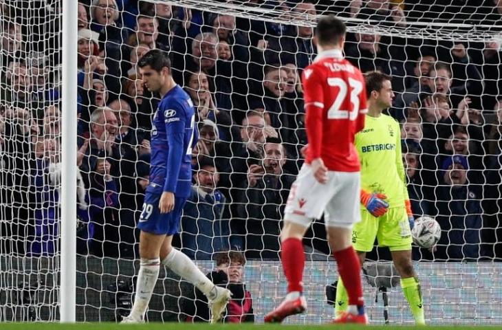 Penyerang Chelsea, Alvaro Morata berjalan melewati kiper Nottingham Forest usai mencetak gol keduanya. Dalam laga babak ketiga Piala FA 2018/19 tersebut, Chelsea menang 2-0 atas Nottingham Forest. Alvaro Morata memborong dua gol untuk kemenangan The Blues. Kemenangan itu membawa Chelsea lolos ke babak keempat Piala FA 2018/19. [ADRIAN DENNIS / AFP]