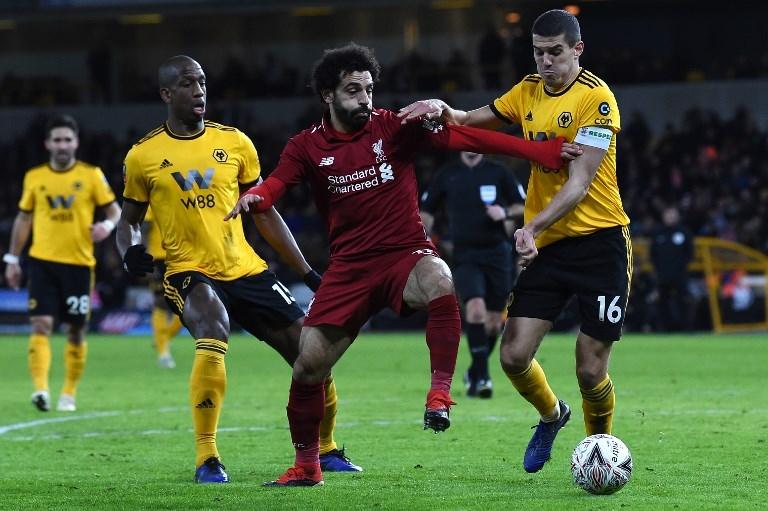 Penyerang Liverpool, Mohamed Salah terlibat duel perebutan bola dengan pemain Wolverhampton pada 7 Januari 2019 (Paul Ellis/AFP)