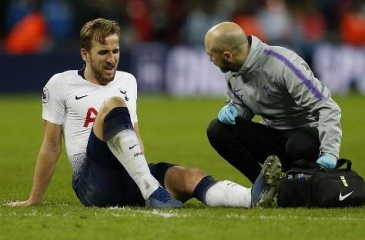 Harry Kane mengerang kesakitan usai ditekel Victor Lindelof saat laga Tottenham kontra Manchester United, Minggu (13/1/2019). (IAN KINGTON / IKIMAGES / AFP)