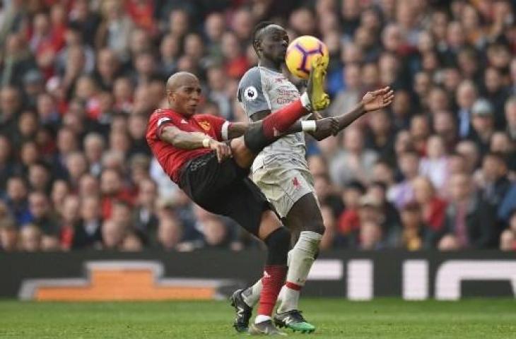 Ashley Young dan Sadio Mane saling berebut bola pada pertandingan Manchester United versus Liverpool di Old Trafford, Minggu (24/2/2019) malam WIB. (OLI SCARFF / AFP)