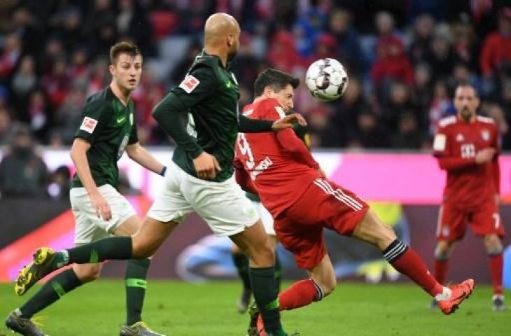 Aksi Robert Lewandowski saat mencetak gol kemenangan Bayern Munich atas VfL Wolfsburg dalam lanjutan Bundesliga di Allianz Arena, Sabtu (9/3/2019) malam WIB. (CHRISTOF STACHE / AFP)