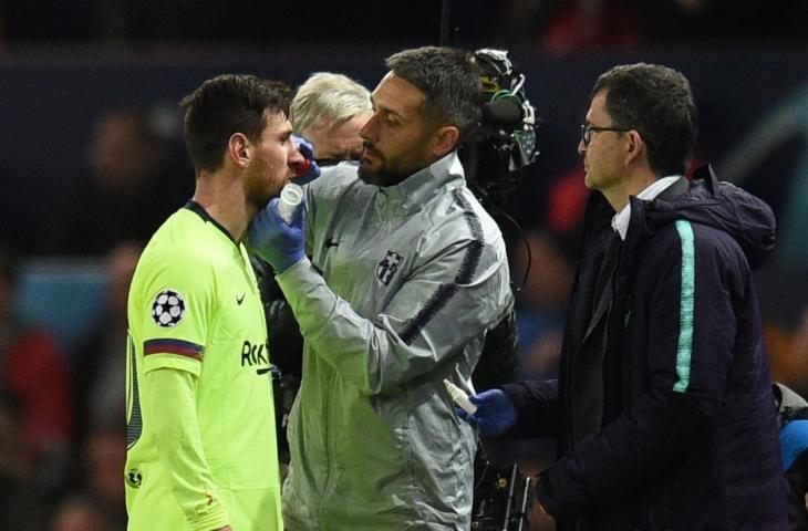 Lionel Messi mendapat perawatan usai dihantam Chris Smalling. (Oli Scraff/AFP)