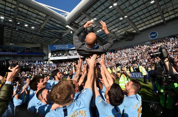 Manajer Pep Guardiola diangkat para pemain Manchester City usai sukses mempertahankan gelar Liga Primer Inggris musim ini. [GLYN KIRK / AFP]