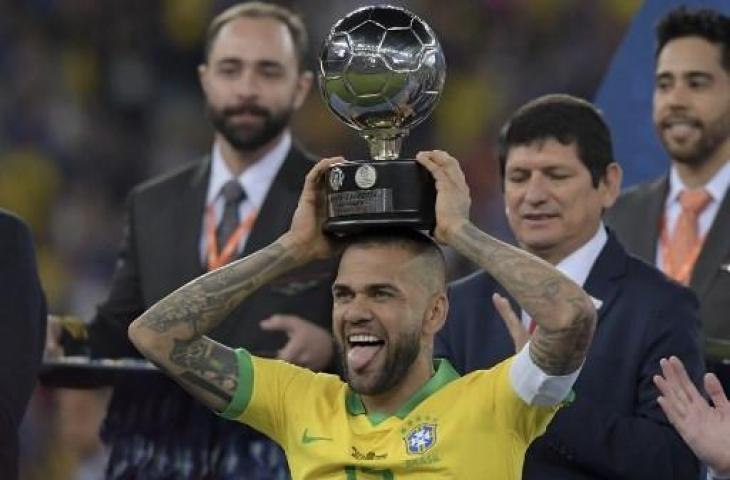 Kapten Timnas Brasil, Dani Alves, saat mengangkat trofi Copa America 2019. (CARL DE SOUZA / AFP)