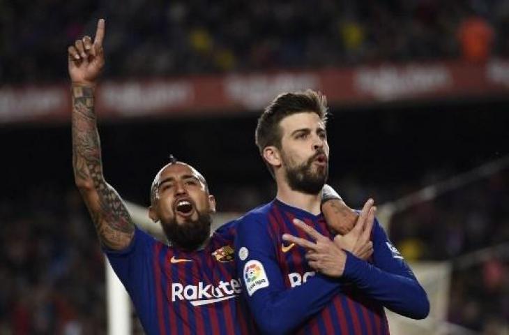 Dua pemain Barcelona, Gerard Pique dan Arturo Vidal. (LLUIS GENE / AFP)