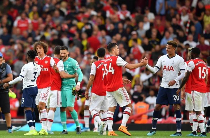 Para pemain Arsenal dan Tottenham Hotspur saling bersalaman usai laga. Pada laga pekan keempat Liga Primer Inggris tersebut berakhir imbang 2-2, Senin (2/9/2019). [BEN STANSALL / AFP]