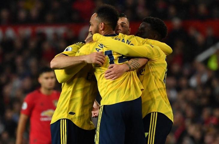 Pierre-Emerick Aubameyang melakukan selebrasi bersama rekan-rekannya usai mampu menjebol gawang Manchester United, Selasa (1/10/2019). Pada laga tersebut MU vs Arsenal berakhir imbang 1-1. [PAUL ELLIS / AFP]