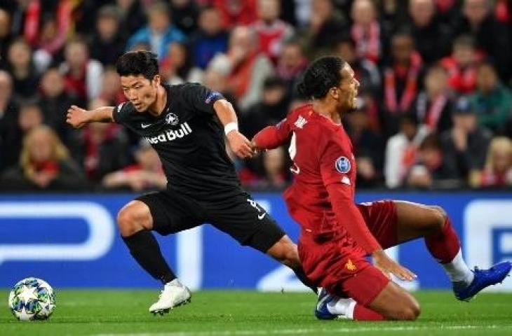 Aksi striker Red Bull Salzburg, Hwang Hee-chan saat mengecoh bek Liverpool, Virgil Van Dijk. (PAUL ELLIS / AFP)