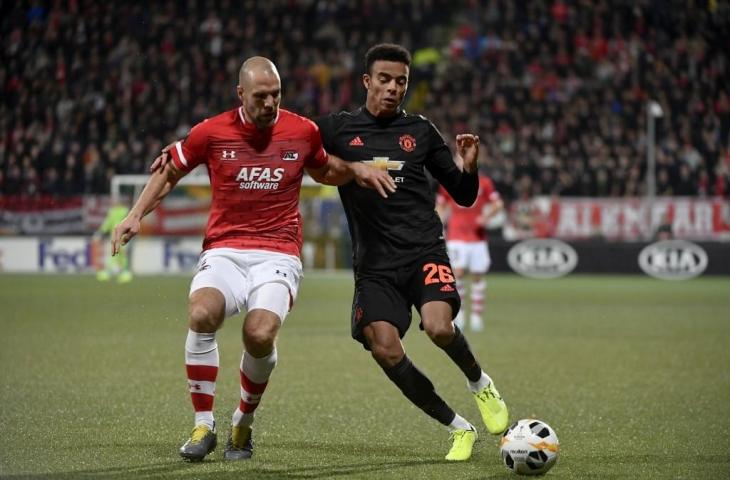 Bek AZ Alkmaar Ron Vlaar berusaha merebut bola dari penyerang Manchester United, Mason Greenwood. Pada laga penyisihan Liga Europa tersebut kedua tim hanya mampu bermain imbang tanpa gol, Kamis (3/10/2019). [JOHN THYS / AFP]