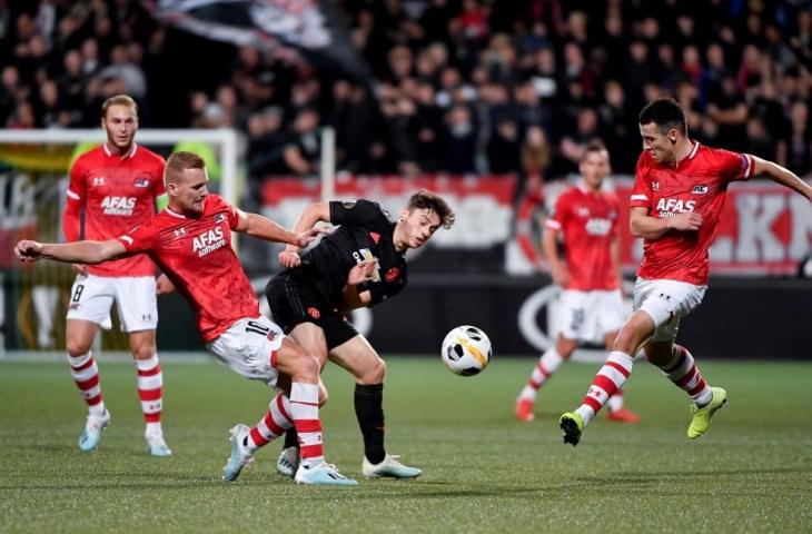 Pemain AZ Alkmaar Dani de Wit berebut bola dengan pemain Manchester United Daniel James. Pada laga Grup L Piala Europa tersebut kedua tim bermain imbang tanpa gol, Jumat (4/10/2019). [JOHN THYS / AFP]