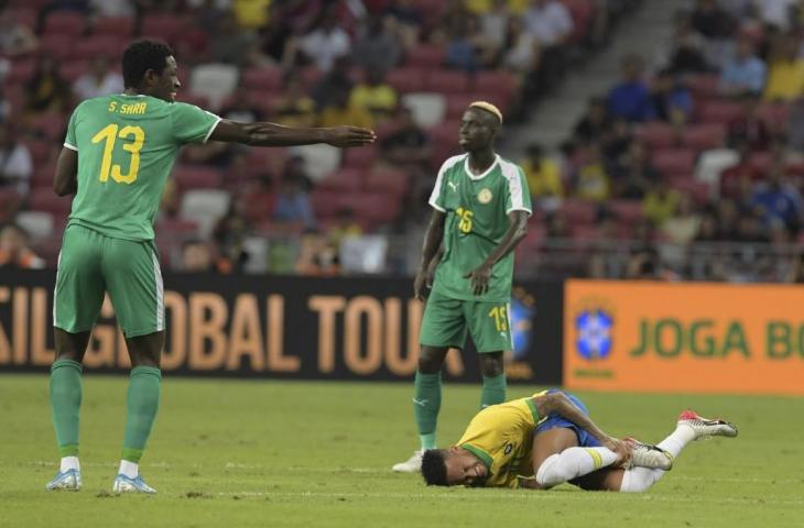 Penyerang Timnas Brasil, Neymar tergeletak kesakitan setelah mendapat cedera di laga persahabatan kontra Nigeria yang berlangsung di National Stadium, Singapura, Minggu (13/10/2019). [ROSLAN RAHMAN / AFP]