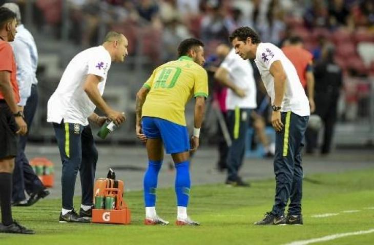 Neymar nampak memegangi paha kirinya saat pertandingan antara Brasil kontra Nigeria. (ROSLAN RAHMAN / AFP)