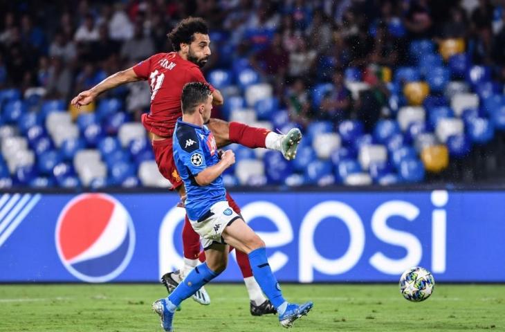 Penyerang Liverpool, Mohamed Salah berusaha melepas tembakan saat dikawal bek Napoli, Mario Rui pada laga Liga Champions leg pertama. [ALBERTO PIZZOLI / AFP]