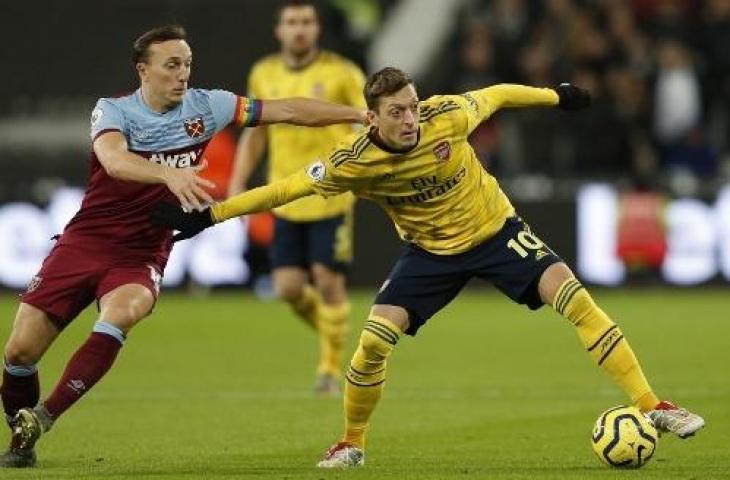 Aksi gelandang Arsenal, Mesut Ozil pada pertandingan melawan West Ham United. (ADRIAN DENNIS / AFP)