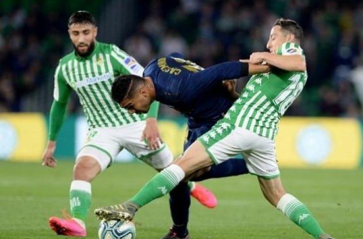 Gelandang bertahan Real Madrid, Casemiro berebut bola dengan gelandang Real Betis, Andres Guardado. Betis menang 2-1 atas Real Madrid, Senin (9/3/2020). (Foto: AFP)