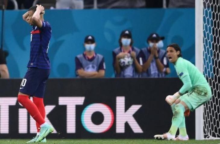 Reaksi Yan Sommer (kanan) setelah berhasil menghadang tendangan Kylian Mbappe (kiri) pada adu penalti laga Swiss vs Prancis, Minggu (20/6/2021). (Franck Fife/AFP)