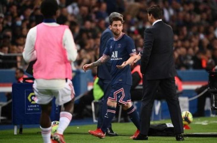 Lionel Messi (kiri) memperlihatkan gesture kebingunan yang ditujukan kepada pelatih PSG Mauricio Pochettino pasca diganti di tengah laga PSG vs Lyon dalam lanjutan Ligue 1 Prancis di Parc des Princes, Paris, Senin (20/9/2021) dini hari WIB. (FRANCK FIFE / AFP)