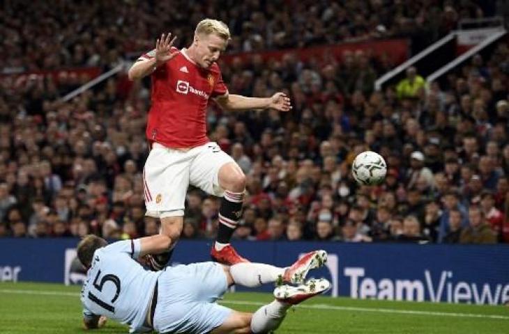 Aksi gelandang Manchester United, Donny van de Beek (kiri) saat berebut bola dengan pemain West Ham dalam laga putaran ketiga Piala Liga Inggris di Old Trafford, Kamis (23/9/2021) dini hari WIB. (Oli SCARFF / AFP)