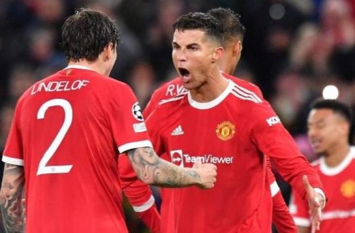 Penyerang Manchester United, Cristiano Ronaldo (tengah) merayakan kemenangan timnya bersama Victor Lindelof usai berakhirnya matchday kedua Grup F kontra Villarreal di Old Trafford, Kamis (30/9/2021) dini hari WIB. (AFP/Anthony Devlin)