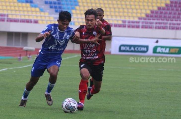 Pemain PSCS Cilacap Kasim Botan (kiri) berduel dengan pemain AHHA PS Pati, Mochamad Rikza dalam lanjutan Liga 2 Grup C di Stadion Manahan, Solo, Senin (4/10/2021). [Suara.com/Ronald Seger Prabowo]