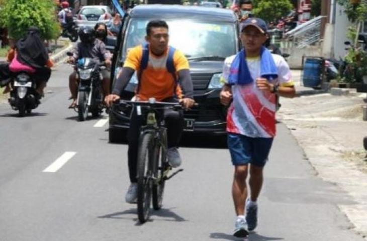 Khoirudin Mustakim, atlet pencak silat peraih emas PON XX Papua untuk Jawa Tengah berlari melintasi Desa Krajan, Jatinom, Klaten, Senin (18/10/2021). [Solopos-Taufiq Sidik Prakoso]