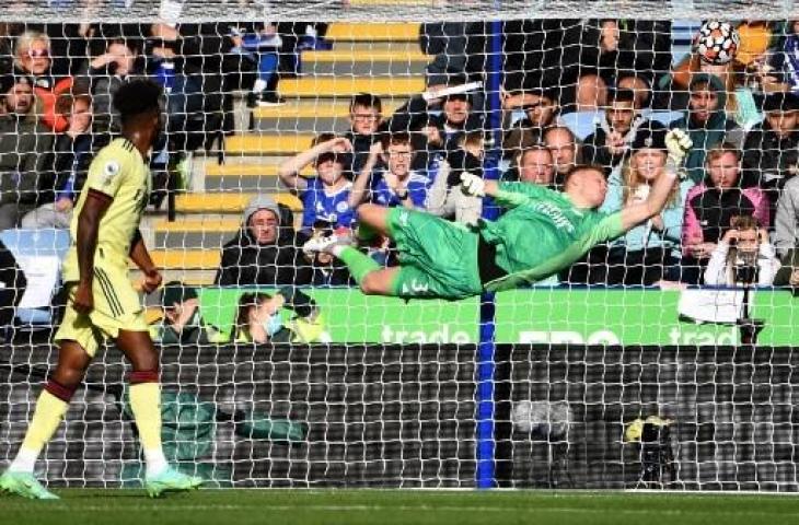 Aksi kiper Arsenal, Aaron Ramsdale saat menggagalkan tendangan bebas cantik pemain Leicester, James Maddison. (JUSTIN TALLIS / AFP)