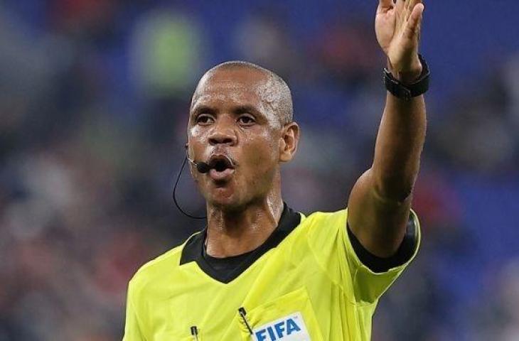 Wasit Zambia Janny Sikazwe memberi isyarat selama pertandingan sepak bola grup B Piala Arab FIFA 2021 antara UEA dan Suriah di Stadion 974, sebelumnya dikenal sebagai Ras Abu Aboud, di Doha pada 30 November 2021. KARIM JAAFAR/AFP