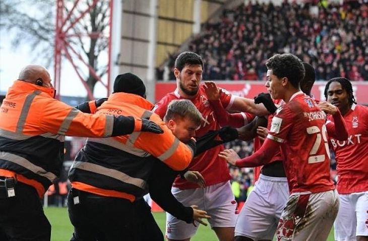 Seorang suporter memukul bek Nottingham Forest, Joe Worrall, yang sedang merayakan golnya ertandingan sepak bola putaran keempat Piala FA Inggris antara Nottingham Forest dan Leicester City di The City Ground di Nottingham, Inggris tengah, pada 6 Februari, 2022. JUSTIN TALLIS/AFP