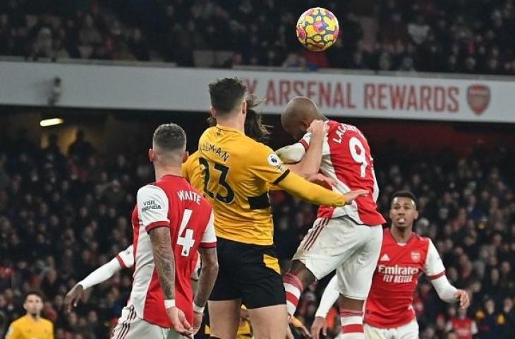 Striker Arsenal Alexandre Lacazette berebut bola dengan pemain Wolverhampton Max Kilman di lanjutan Liga Inggris, Jumat (25/2/2022) dini hari WIB. (AFP/Glyin Kirk)